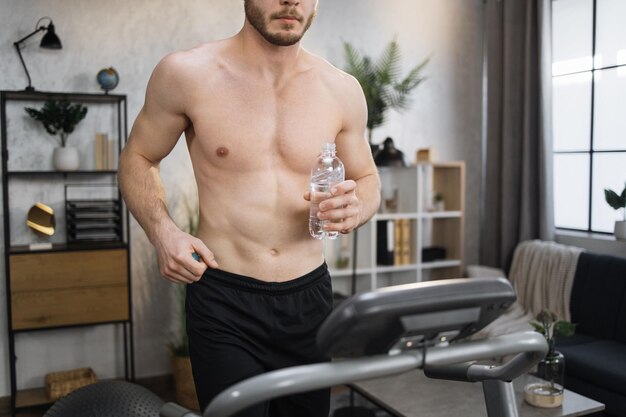 Bijgesneden portret van handen met fles water van actieve sportieve man