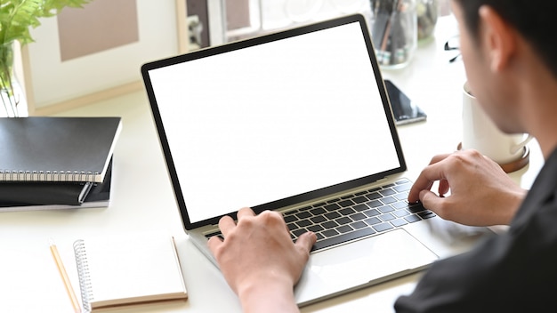 Bijgesneden schot man handen met behulp van laptopcomputer op kantoor aan huis met bijgesneden schot.