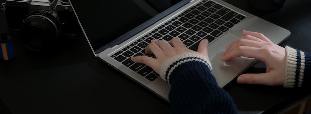 Bijgesneden schot van zakenvrouw werken op laptop op zwarte tafel