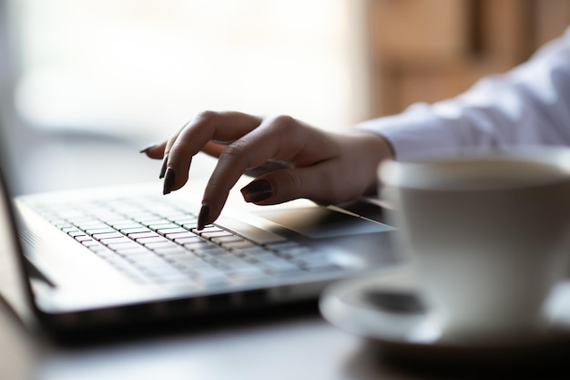 Bijgesneden schot weergave van jonge vrouw toetsenborden op laptopcomputer met lege kopie ruimte scherm zittend in café, blonde vrouwelijke student werkt aan net-boek na haar lezingen aan de universiteit, flare zon