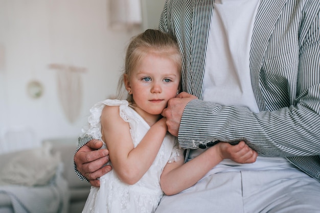 Bijgesneden shoot van vader die kleine blonde dochter kalmeert die gefrustreerd is, heeft meer aandacht nodig Verdrietig meisje