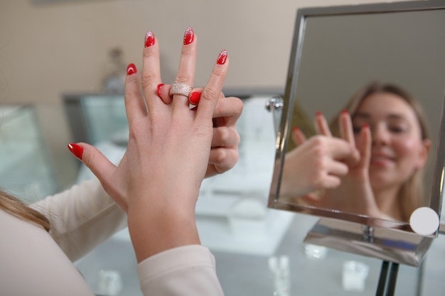 Bijgesneden shot van een vrouw diamanten ring zetten bij juwelier