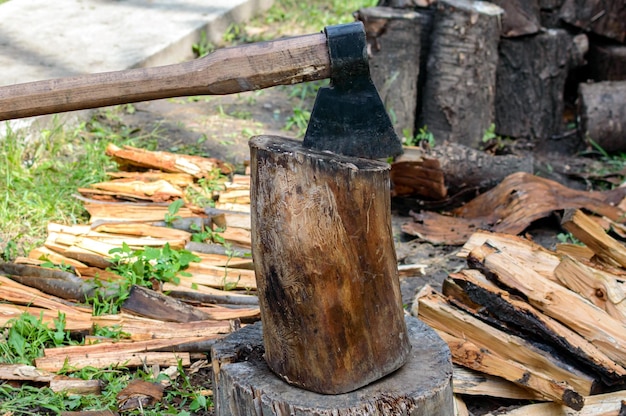 Foto bijl in log, stapel brandhout. bijl klaar voor het zagen van hout. een stapel vers gehakte houten stammen