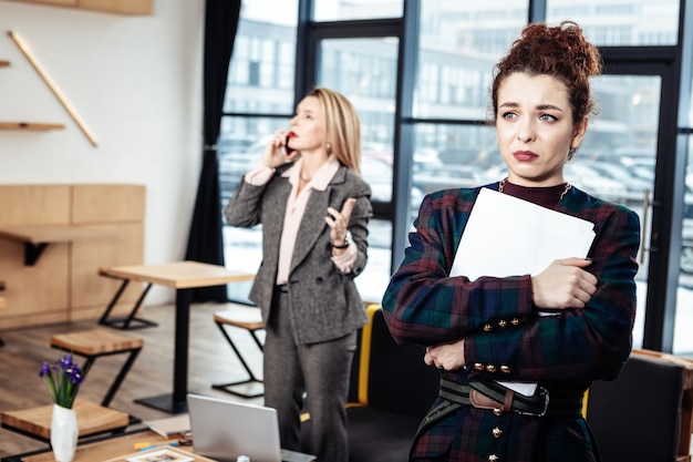 Bijna huilen. Jonge onervaren aantrekkelijke secretaresse die de strikte vrouwelijke baas bijna huilend achterlaat