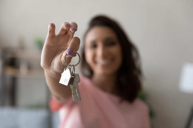 Bijsnijden close-up van vrouwelijke huurder huurder Toon lof huissleutels verhuizen naar eerste eigen nieuw appartement of huis gelukkige vrouw eigenaar kopen aankoop huis verhuizen naar woning huur huur eigendom concept