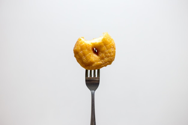 bijt doughnut met vork op wit geïsoleerde achtergrond