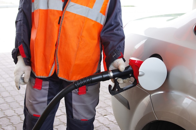 Bijtankende werknemer tankt de auto bij met benzine