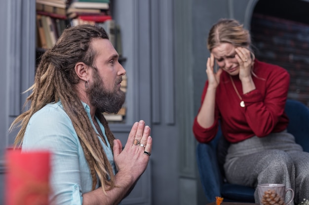 Bijzonder ritueel. Aardige man met een baard die zijn handen in elkaar steekt tijdens het uitvoeren van een speciaal ritueel