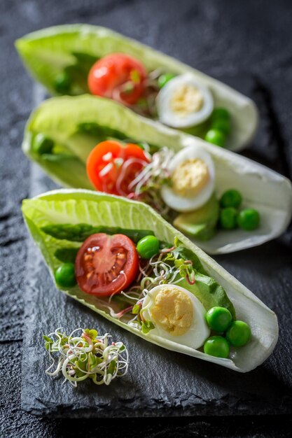 Foto bijzondere salade in witlof met kwarteleitje tomaat en avocado