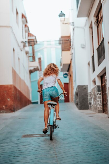 Photo bike attractive and happy woman on vacation tackles a climb female riding bicycle in summer ecofriendly transport to reduce the carbon footprint of women who cycle