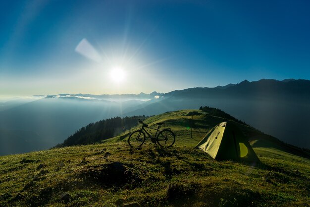 Bici nel campo della bicicletta contro il fondo del cielo al tramonto