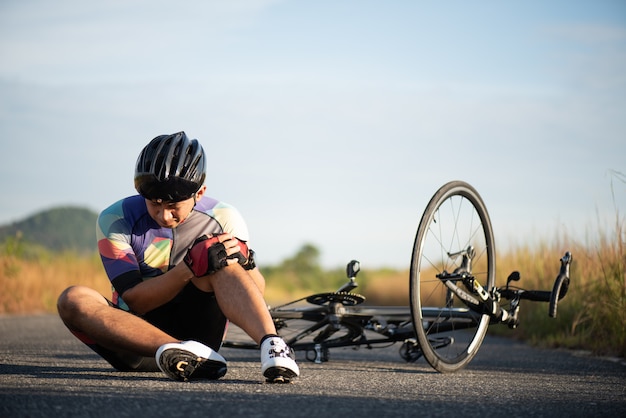 Bike injuries. Man cyclist fell off road bike while cycling.