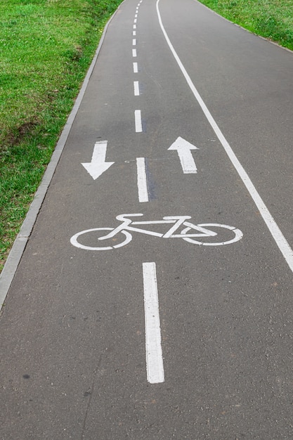 Foto segnale della pista ciclabile, verniciato bianco su strada asfaltata