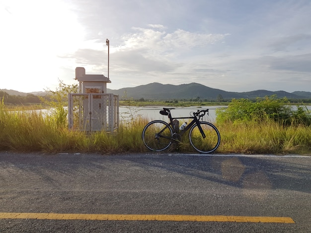 Bike parked beside open road with blue sky 