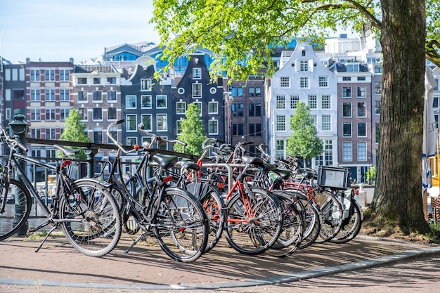 Photo bike parked on a canal bridge amsterdam traditional facade house background netherlands holland
