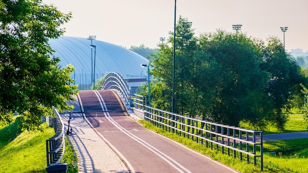 Bike path in city park in early morning in summer