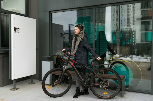自転車レンタルコンセプト 街で自転車に乗っている若い白人女性