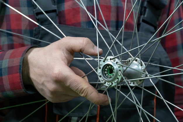 Bike repair A mechanic holds in his hand the front wheel of a road bike Maintenance of the hub replacement of grease and bearings