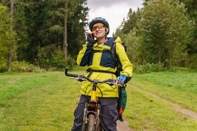 Bikepacker stopt midden in het bos en praat aan de telefoon