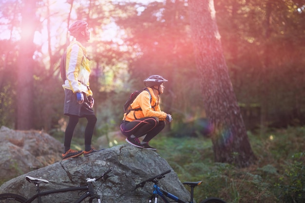 Biker couple looking at a view in forest