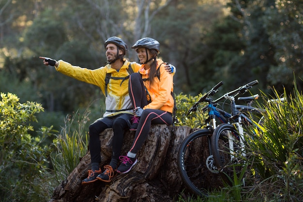 Biker couple sitting and pointing in distance