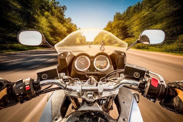Foto il motociclista alla guida di una moto percorre la strada asfaltata. visuale in prima persona.