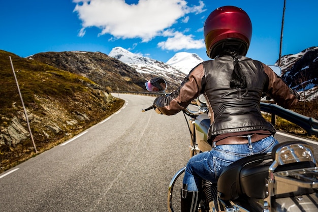 Foto la ragazza del motociclista guida una moto sotto la pioggia. visuale in prima persona.