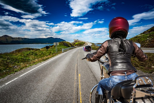 Biker girl rides a mountain road in Norway Atlantic Ocean Road. First-person view.