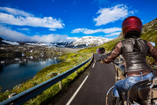 Biker girl rides a mountain road in Norway. First-person view.