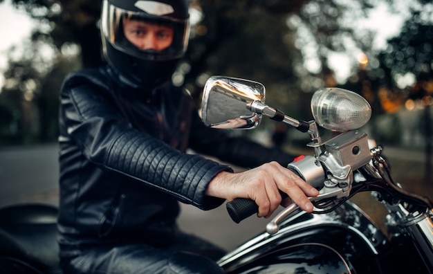 Biker in casco posa su una moto, chopper classico. bici vintage, pilota e il suo amico a due ruote, stile di vita in libertà, ciclismo