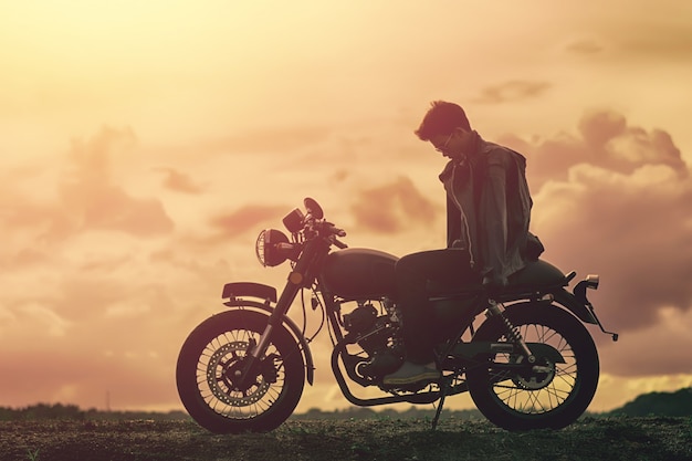 Foto uomo del motociclista con la sua moto accanto al lago naturale e bello.