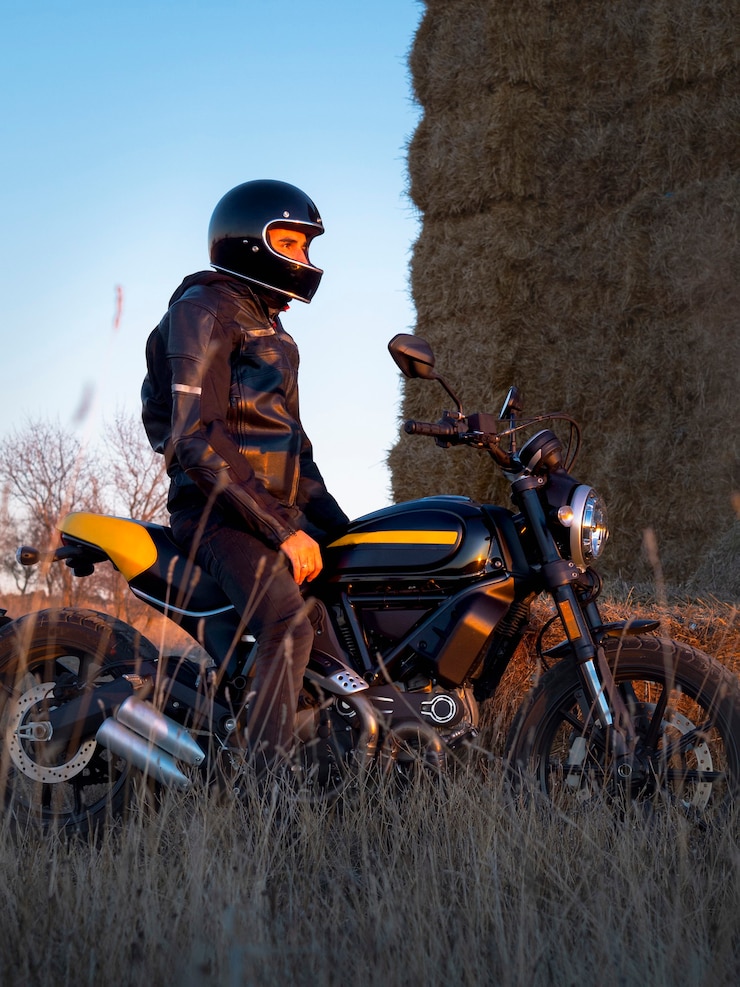 Photo biker man with his motorcycle at sunset