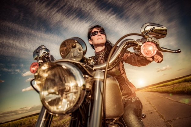 Biker meisje in een leren jas op een motorfiets