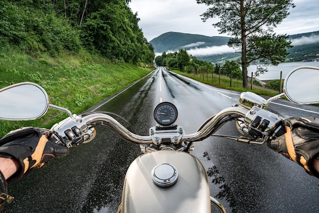 Biker rijdt op een motorfiets in de regen. Eerstepersoonsperspectief.