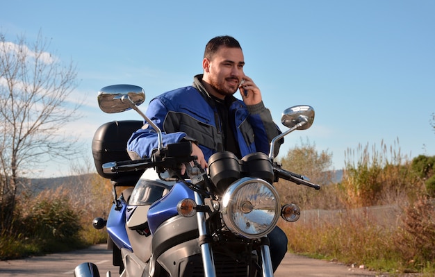 Motociclista che parla al telefono con il suo telefono smarth