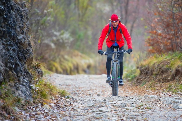 Biker with mountain bike downhill on dirt road