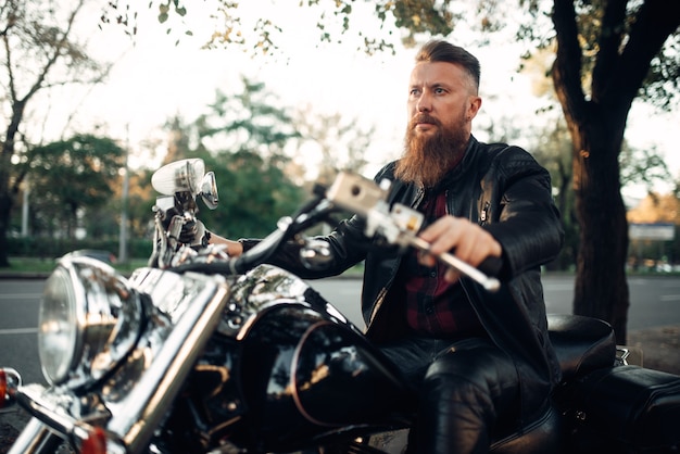 Biker zittend op een motorfiets, klassieke bijl.