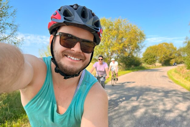 Bikers taking selfie with smiling friends riding bikes Biking outdoors with friends Bonding time