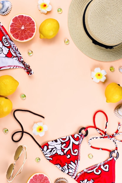 Фото Купальник бикини с соломенной шляпе, цветы и фрукты, плоский дизайн, концепция лето. пляжное направление, летняя мода