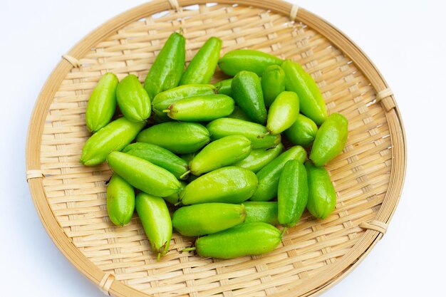 Photo bilimbi fruit in bamboo basket on white background