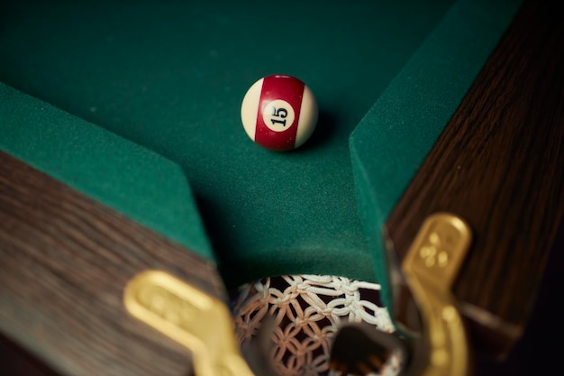 Foto palla da biliardo vicino al foro pool ball numero fortunato 15 vicino al foro sul tavolo da biliardo verde