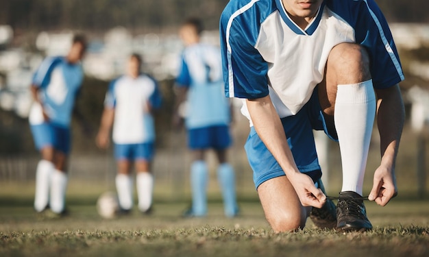 Bind man of voetballer met schoenen op voetbalveld tijdens trainingsoefening of training in Brazilië Kantstadion of handen van atleet klaar om te beginnen met fitnesswedstrijd of sportwedstrijd met laarzen of schoeisel