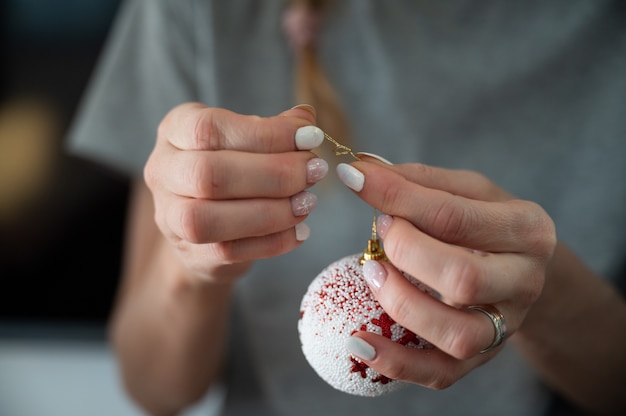 Bindende gouden koord aan een rode en witte kerstbal