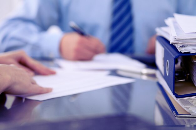 Binders with papers are waiting to be processed by bookkeepers back in blur. Accounting planning budget, audit, insurance  and business concept