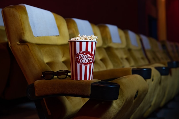 Binnen lege bioscoop bioscoop gele stoelen met popcorn en zonnebril