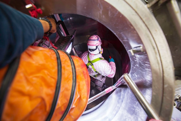 Binnen mannelijke twee werknemer in de inspectie glanzende tank roestvrij chemische blower frisse lucht