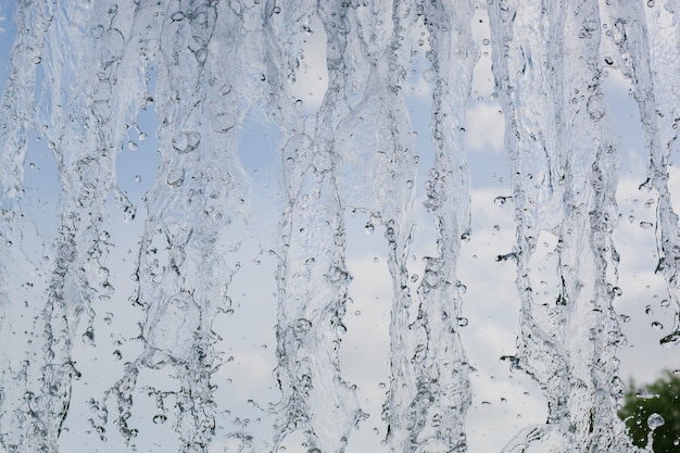 Binnenaanzicht van het vallende water van de waterval tegen de blauwe lucht. mooie textuur van bevroren water in beweging.