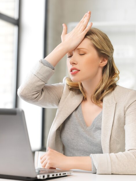 binnenfoto van zakenvrouw die haar hoofd met de hand vasthoudt