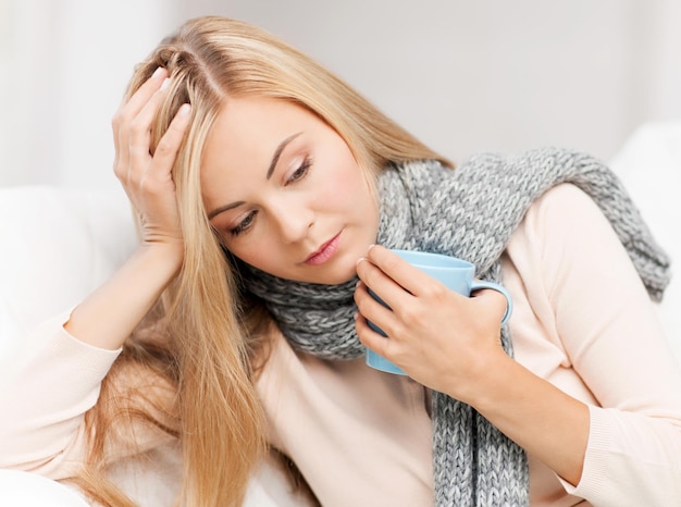 Binnenfoto van zieke vrouw met kopje thee