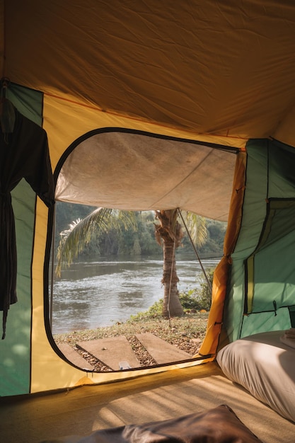 Binnenkant van grote comfortabele kampeertent op camping in het tropische bos aan de rivier op vakantie